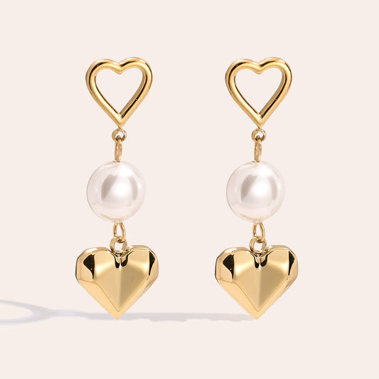 Stilvolle Pearl & Heart Ohrstecker mit einer Perle und Herzdesign, die deinem Outfit eine charmante Note verleihen.