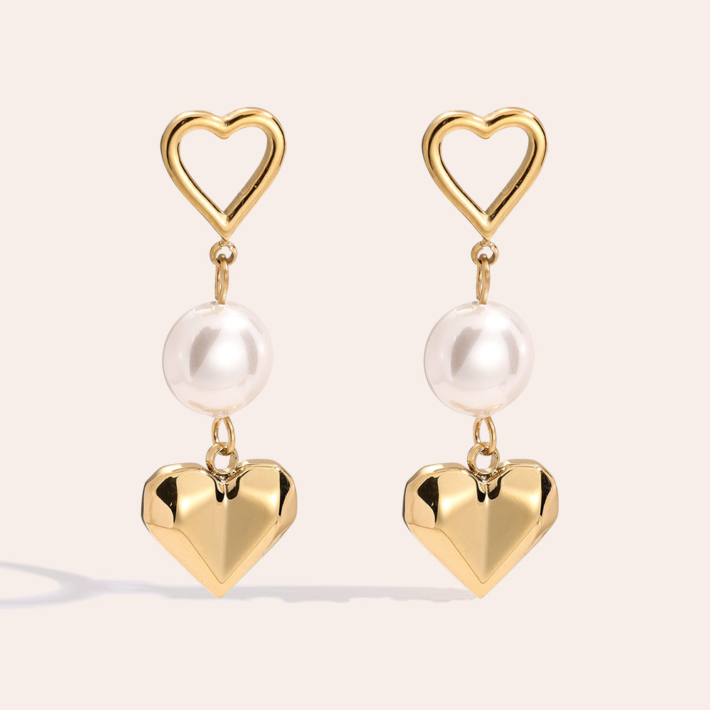 Stilvolle Pearl & Heart Ohrstecker mit einer Perle und Herzdesign, die deinem Outfit eine charmante Note verleihen.